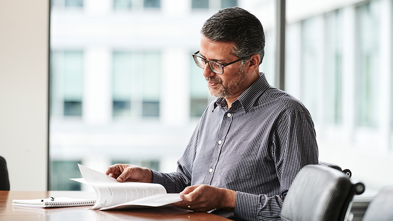 Homme lisant ses notes, assis dans un bureau